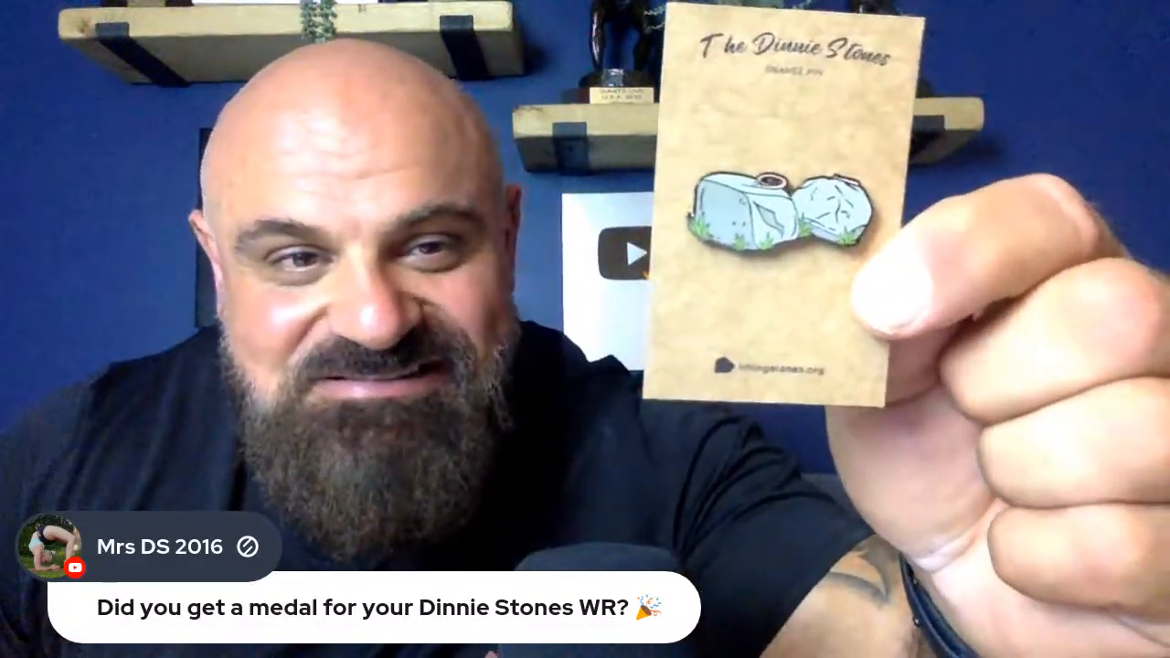 Big Loz holds shows off Dinnie Stones enamel pin during a livestream.