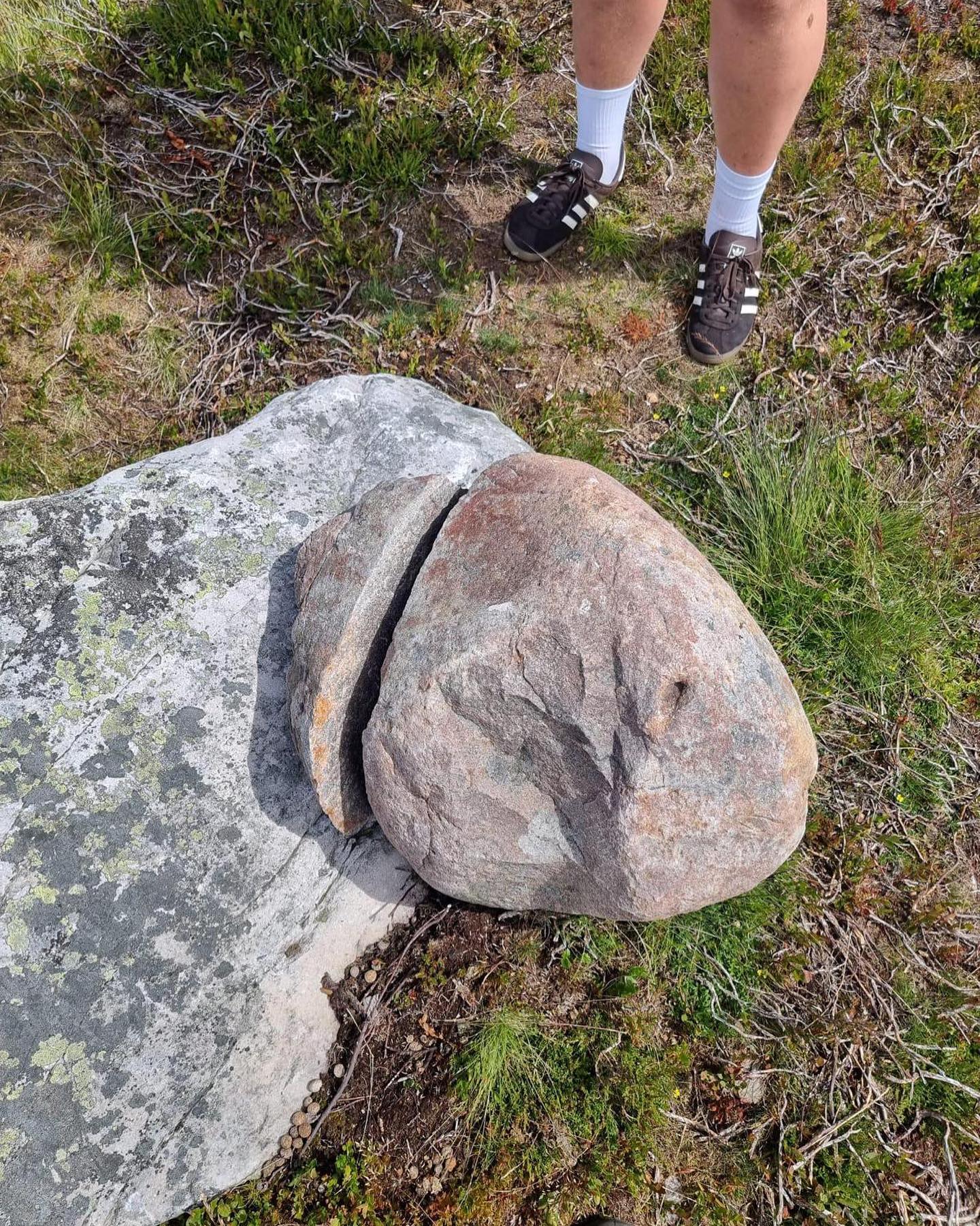 A photo of a broken lifting stone. A large chunk is clearly separated from the stone.