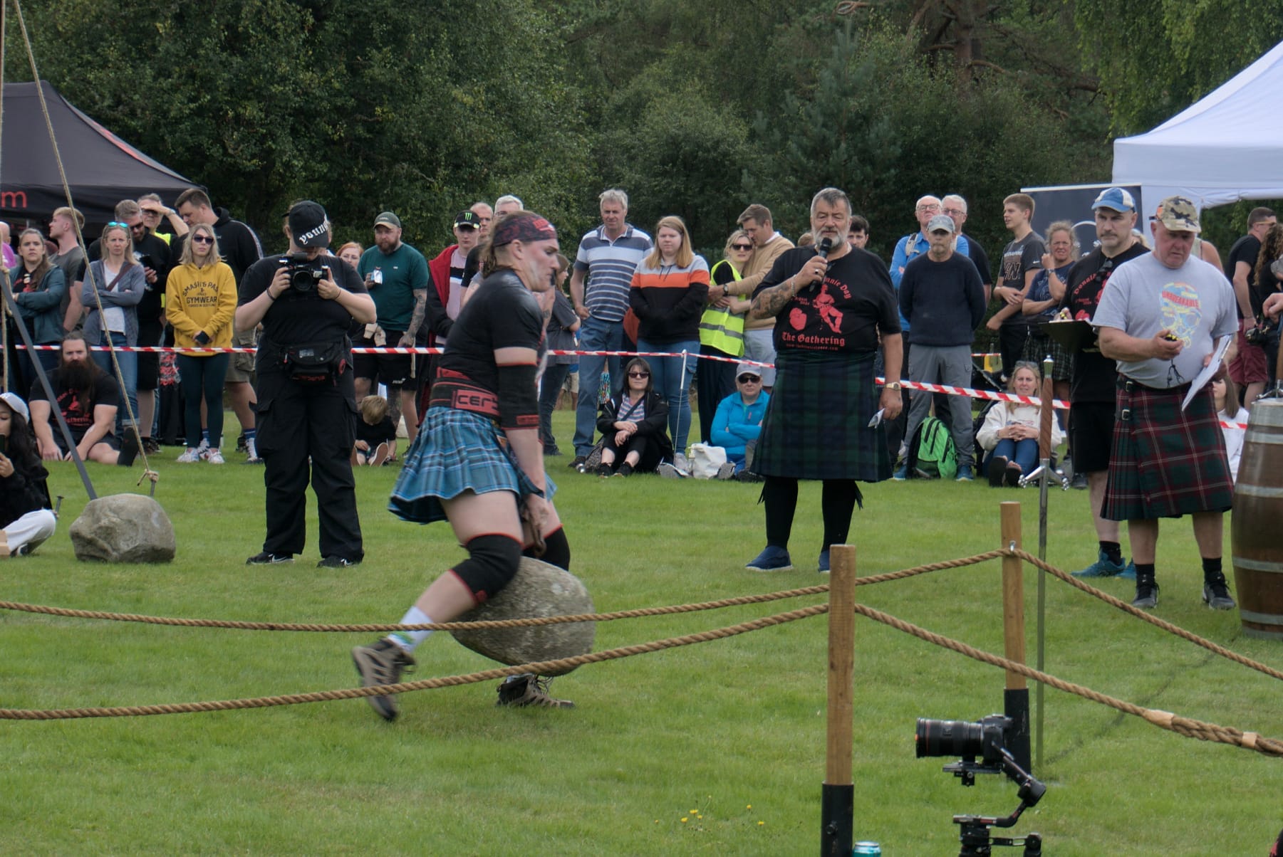 A slightly out-of-focus woman takes huge steps with a stone swinging between her legs.