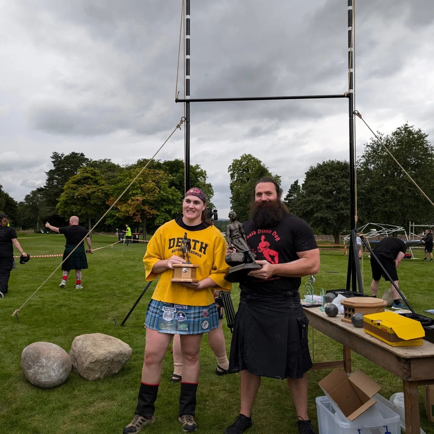 A woman and a man hold their winners trophies as they pose for a photo.