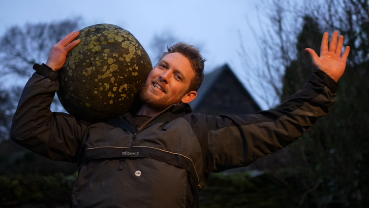 A still frame of Calum Stott lifting a stone from the BBC report produced by Jonathan Swingler